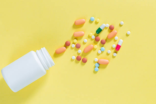istock pills and pill bottles on yellow background,White pills and white bottle with copy space on yellow background, Healthy and Medicine concept. 1361708659