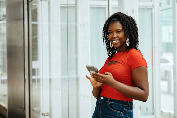 istock african american woman using smartphone and smiling 1361709586