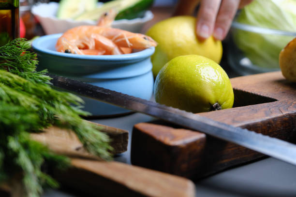 Human hands are preparing shrimp and avocado sandwiches on ciabatta