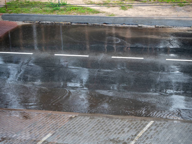 istock Heavy rain drops falling on city street during downpour 1361711240