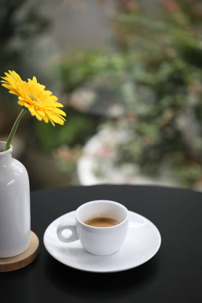 istock Coffee in a white ceramic cup with yellow gerbera flower 1361712444