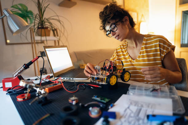 istock Female programmer starting the prototype of autonomous self-driven robotic car with sensor via open-source hardware and software platform, on her laptop 1361713423