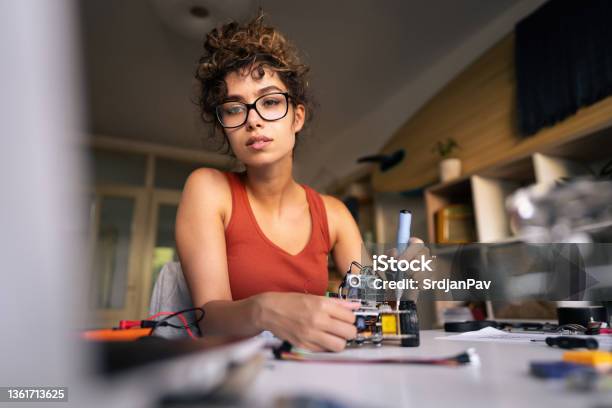 Female Programmer And Engineer Adjusting The Autonomous Selfdriving Robotic Car With Sensors Via Arduino Software Platform In Her Creative Home Workshop Stock Photo - Download Image Now