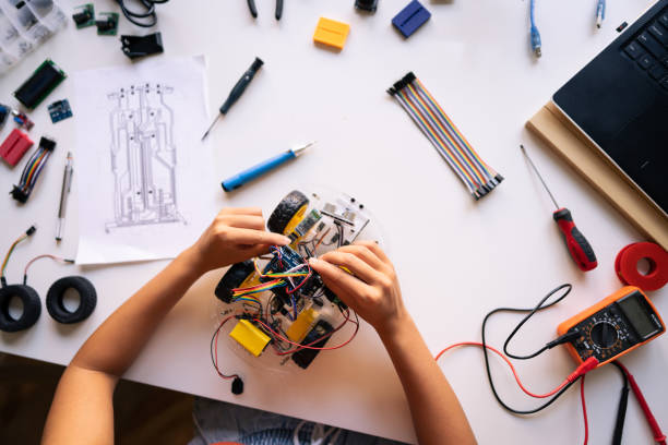 istock Unrecognizable female programmer and engineer, connecting cables of the autonomous self-driving robotic car with sensors with the motherboard i 1361713647