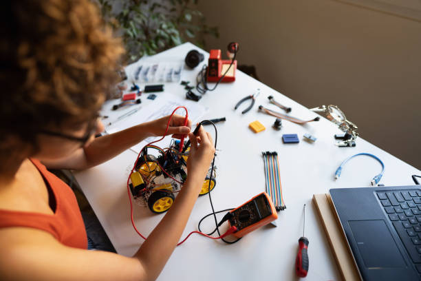istock Unrecognizable female robotic engineer using multimeter to read the electrical voltage of a prototype of autonomous self-driving robot car with sensors 1361713676