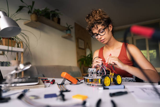 istock Dedicated female engineering student using multimeter to read the electricity on the mother board of the robotic car toy 1361713689