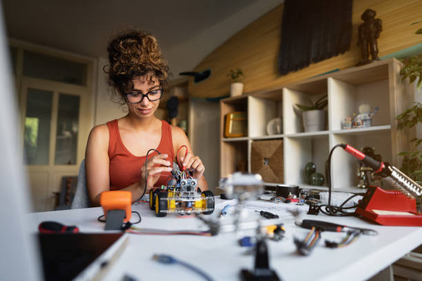istock Female robotic engineer, using multimeter to read the electric voltage of autonomous self-driving robot car with sensors prototype 1361713700