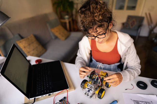 istock Female programer and engineer, adjusting the autonomous self-driving robotic car with sensors in her creative home workshop 1361713726