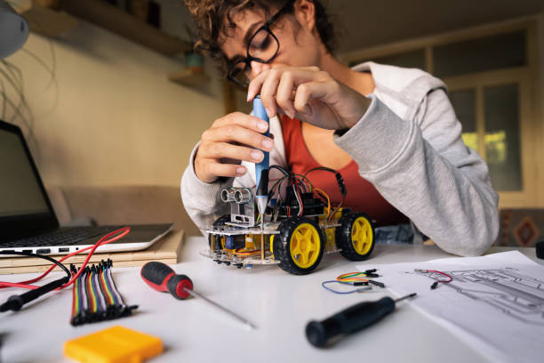 istock Dedicated female programmer and engineer, at her workshop, improving the prototype of the robotic car she working on 1361713743