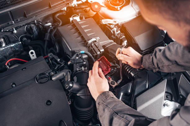 Auto Repair Shop or Auto Service. Replacing a car battery. Disconnecting the car battery terminal. Scheduled vehicle inspection. stock photo