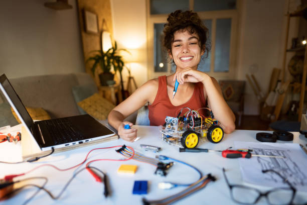 istock Proud and passionate female robotic engineer, working on an autonomous self-drive robotic car, late at night from her home office 1361715014