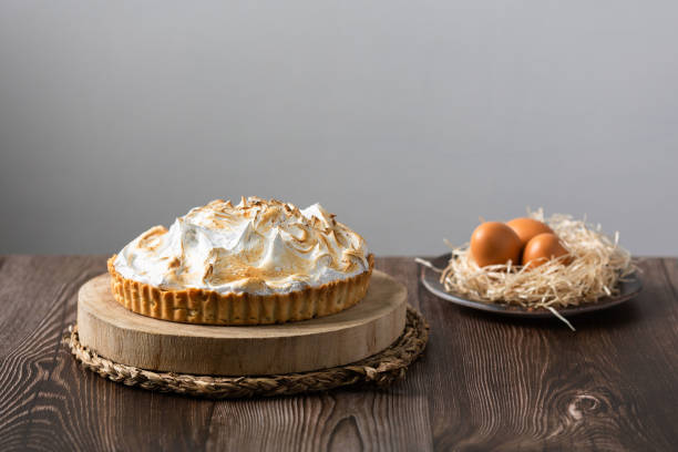 Lemon pie on top of log and wooden table. front view