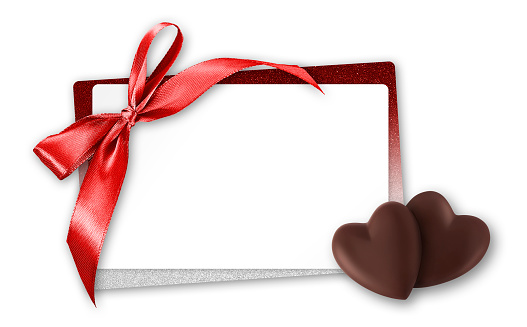 valentines day gift card, heart shaped chocolates with red shiny ribbon bow and white ticket for copy space isolated on white background, top view and also great for mother's day greetings