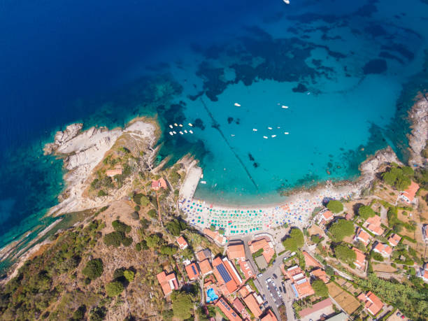 vista de una playa abarrotada a lo largo de la costa frente al mar mediterráneo en la isla de elba, toscana, italia. - portoferraio fotografías e imágenes de stock