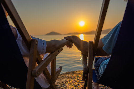 woman relaxing on a hammock enjoying sunset by the swimming-pool