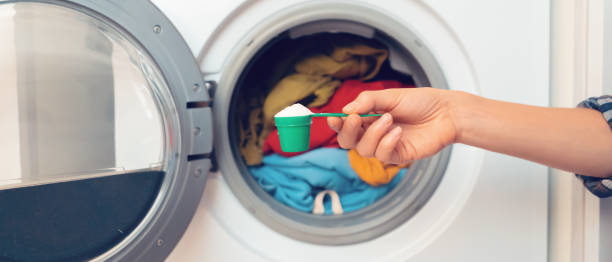 female hand holds a cap with washing powder. - uitbeenhandschoen stockfoto's en -beelden