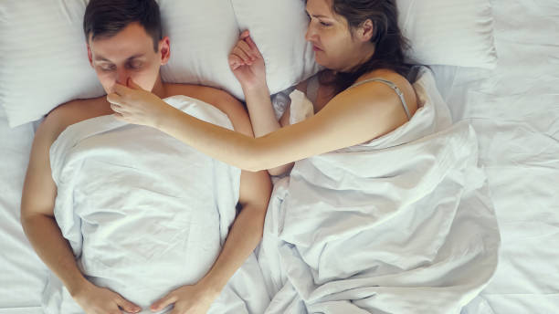 la mujer embarazada se irrita por los ronquidos de la pareja mientras duerme - couple love snoring sleeping fotografías e imágenes de stock