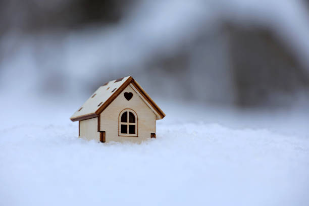 istock Wooden house model in a snow 1361723341