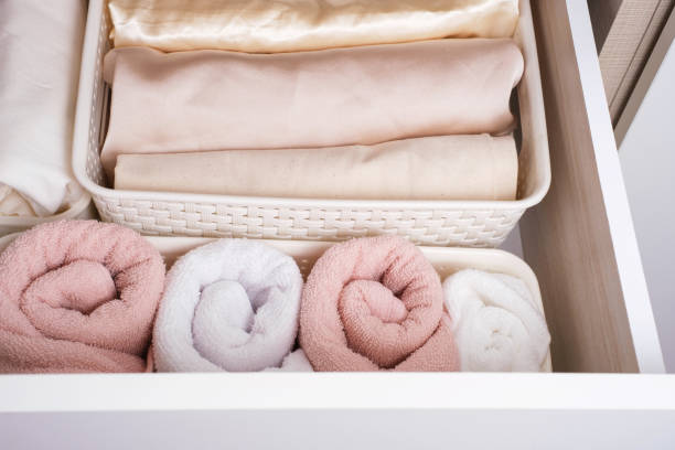 Clothes and towels in plastic containers in a closet top view, space organization concept.