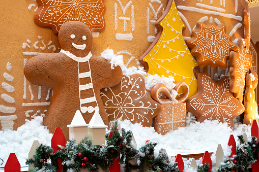 Gingerbread house decorated with colorful candies against a white background