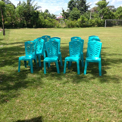 blue plastic chairs arranged in the field