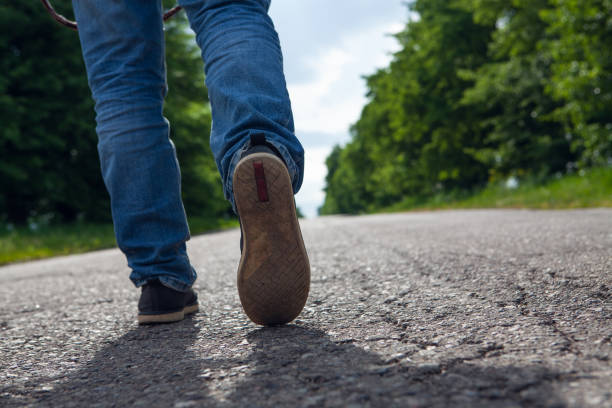 istock a man walks on an asphalt road 1361728199