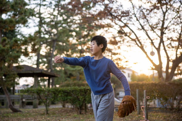 ragazzo che lancia la palla nel parco pubblico - playing catch foto e immagini stock