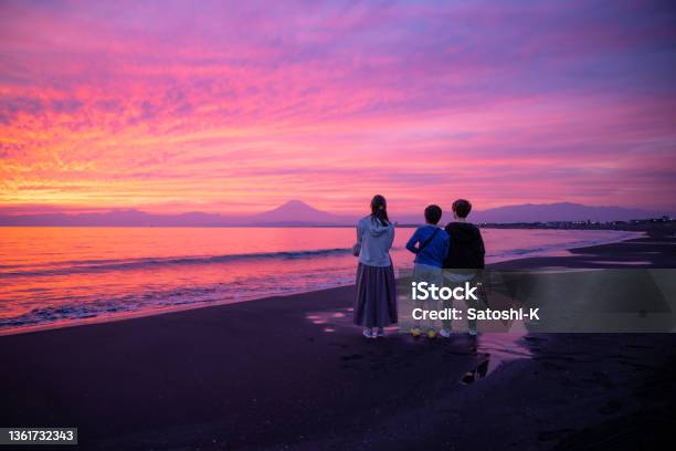 Rear View Of Three People Looking At Mt Fuji From Shonan Beach At Sunset Time Stock Photo - Download Image Now