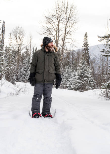 istock Burly Outdoorsman Snowshoeing in Forest 1361733251