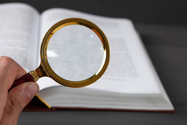 istock open book and magnifying glass. search for books 1361733548