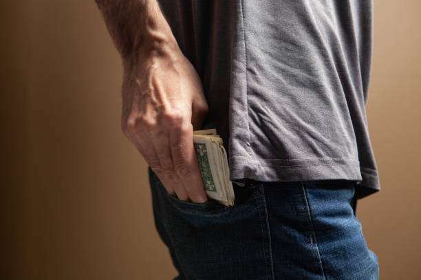 istock man puts money in his back pocket 1361733875