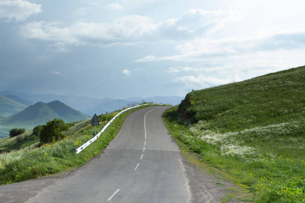 istock asphalt road descends the mountainside in the forest 1361734420