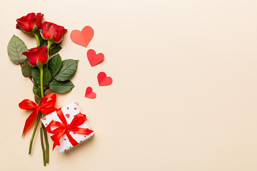 Valentine's day composition with rose flower, red heart and gift boxes on table. mother day and birthday greeting, copy space, top view.