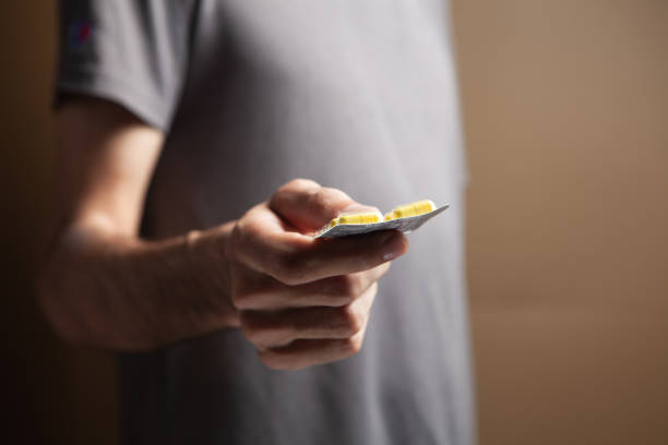 istock a man holding a pill in his hand 1361737980