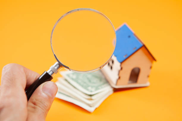 istock magnifier, house and money on a yellow background. 1361738199