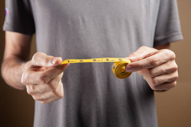 istock a man holding a measuring tape 1361738784