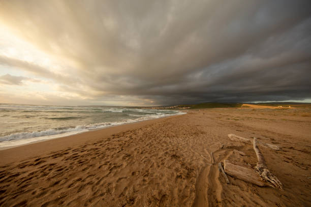 Panoramic view of a beautiful beach along the coast at sunset facing the Mediterranean sea, Sardinia, Italy.
