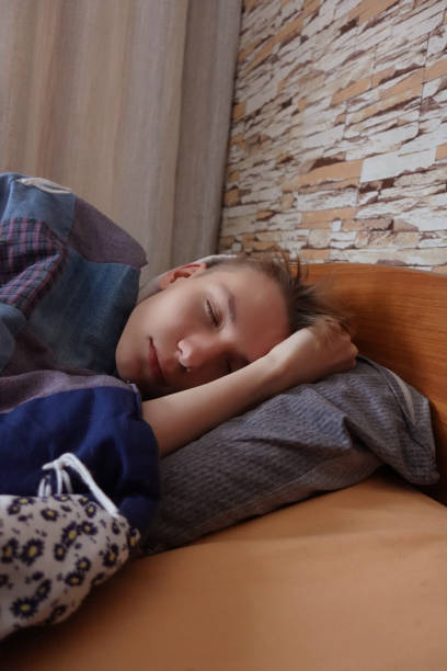 istock A young man with white hair is sleeping in his bed. 1361745997