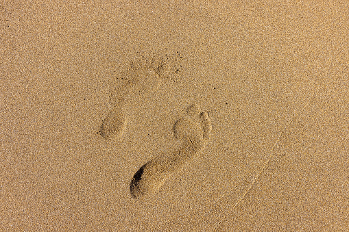 View of woman's footprints on the beach, Sardinia, Italy.