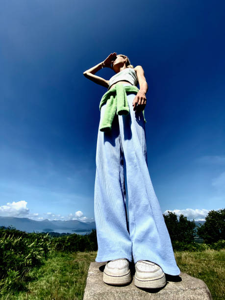 сверхширокий низкоугольный вид девочки-подростка, смотрящей на горизонт - mobilestock freedom enjoyment blue стоковые фото и изображения