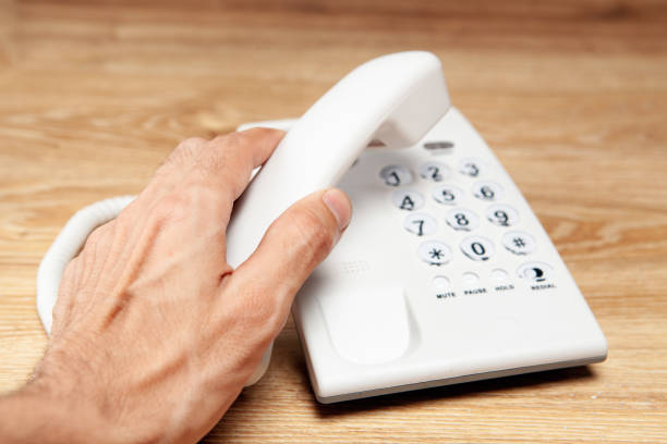 holds the home phone receiver by the table