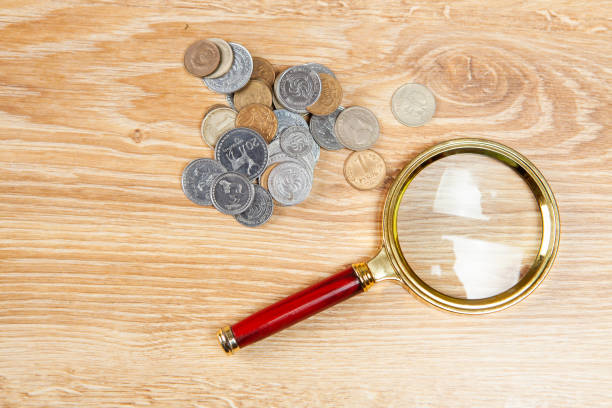 istock coins and a magnifying glass on the table 1361747247