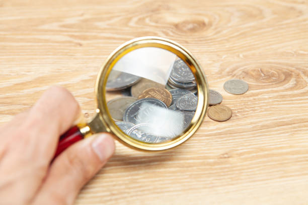 istock coins and a magnifying glass on the table 1361747260