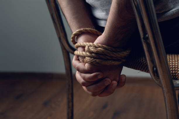 a man is tied on a table with a rope a man is tied on a table with a rope kidnapping stock pictures, royalty-free photos & images