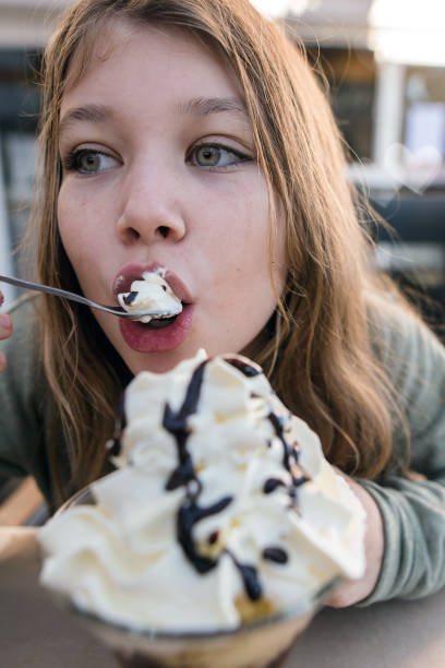istock pretty girl feasting on ice cream with whipped cream 1361748210