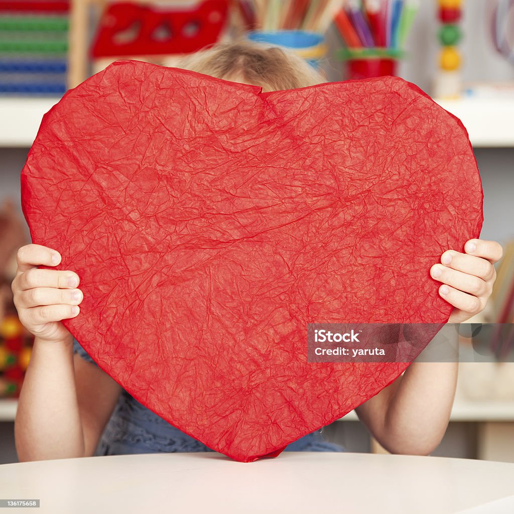 Happy child with paper heart Happy child with big handmade paper red heart in class. Valentine`s day concept Preschool Stock Photo