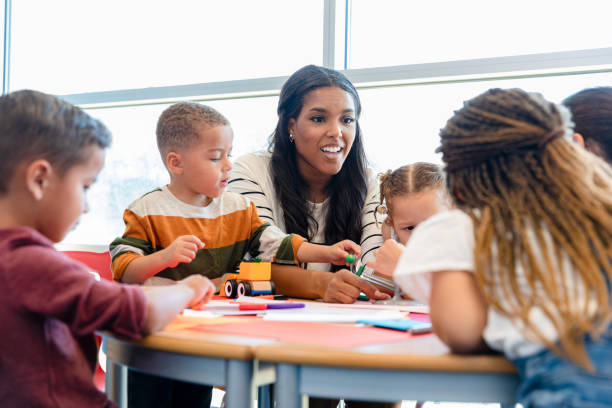 istock Preschool teacher teaches children about solar system 1361756636