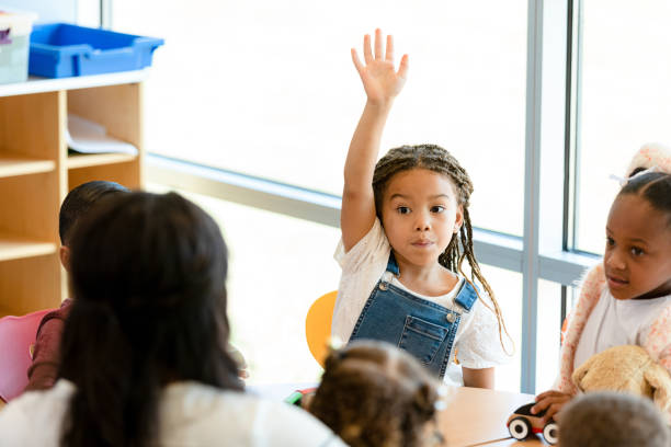 istock Little girl raises hand during preschool class 1361756654