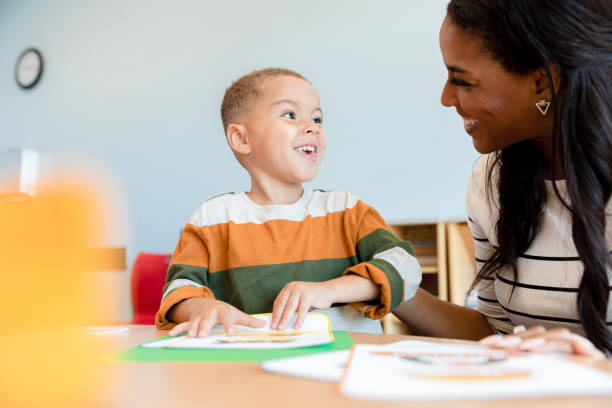 istock Little boy uses emotion flashcards during counseling session 1361756673