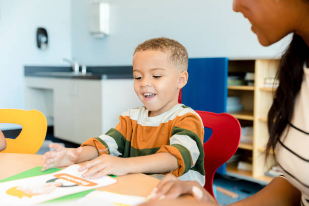 istock Little boy mimics expression on emotion flash cards 1361756682